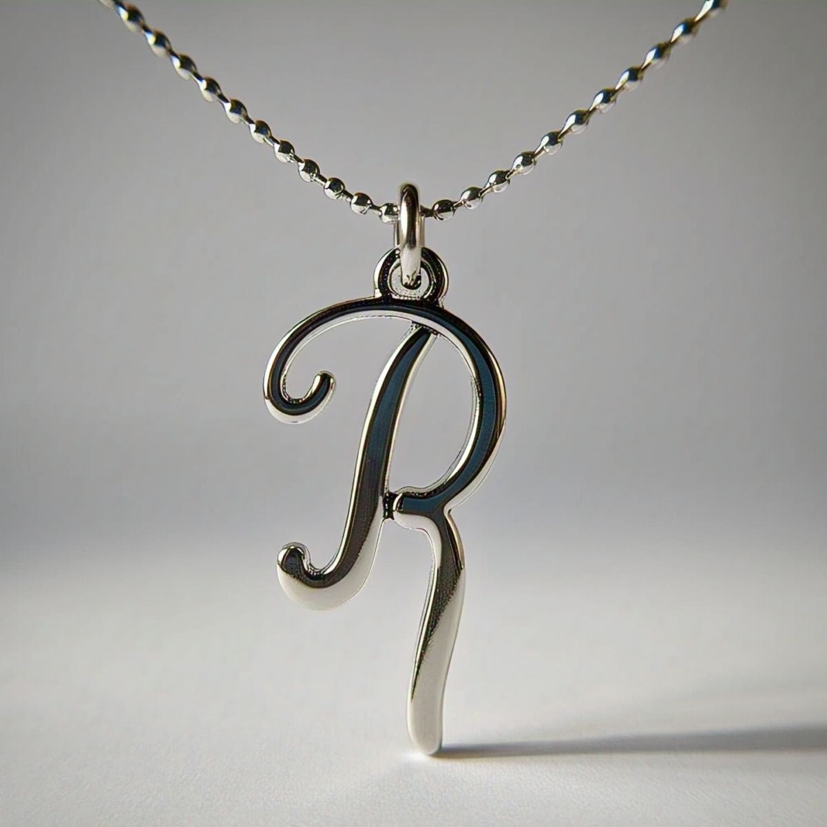 Hand wearing gold single-letter pendant, personalized jewelry