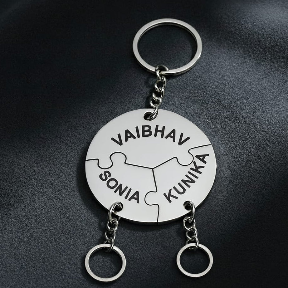 Keychain with puzzle piece design and engraved names on a dark background