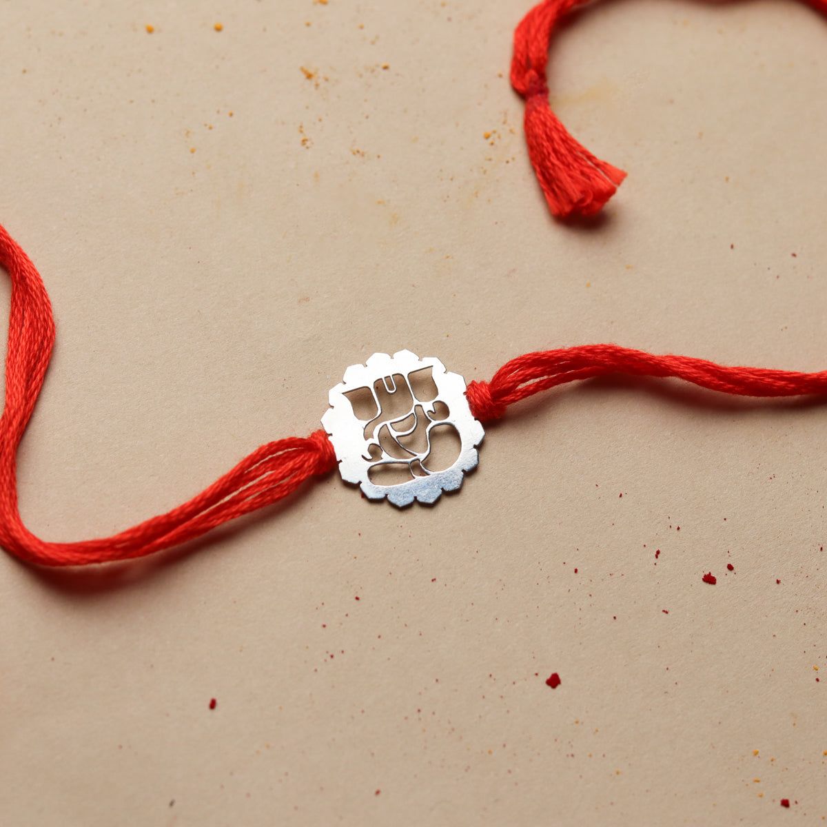 Premium laser cut Rakhi featuring detailed floral design and metallic finish