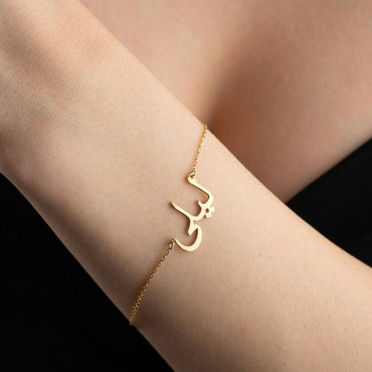 Close-up of custom Arabic calligraphy jewelry bracelet featuring traditional script engraving