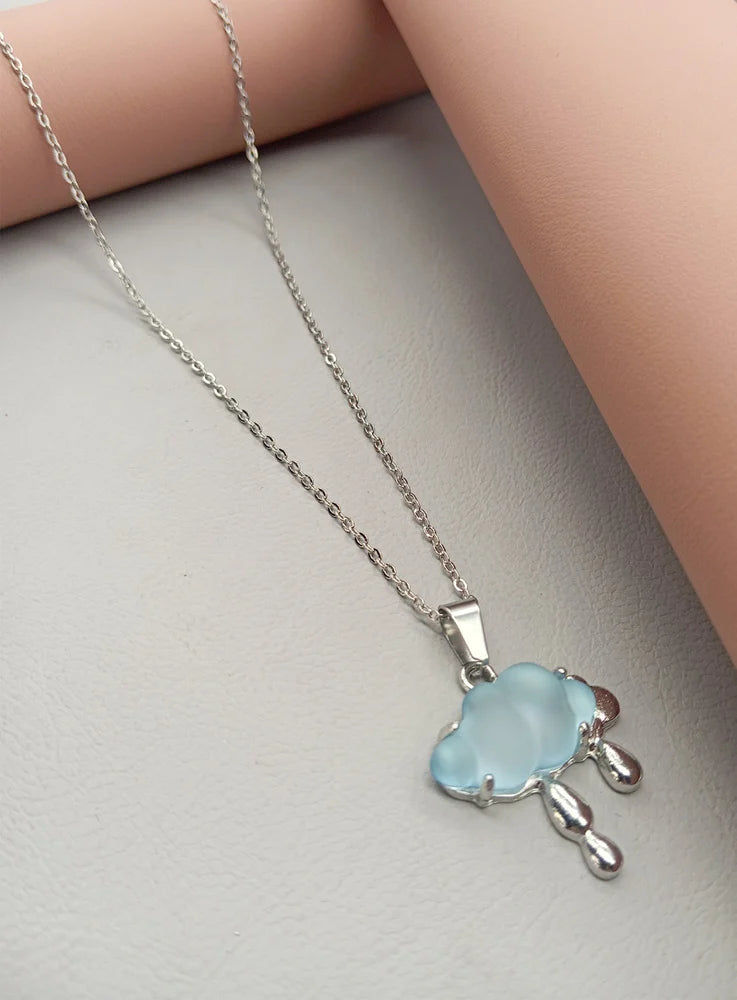 Close-up of blue enamel cloud charm with silver lining.